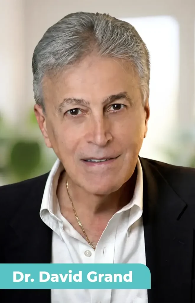 TraumaSolutions An older man with gray hair wearing a white shirt and dark blazer, facing the camera. Text at the bottom reads "Dr. David Grand." Known for developing Brainspotting, he specializes in deep processing to help clients heal from trauma.