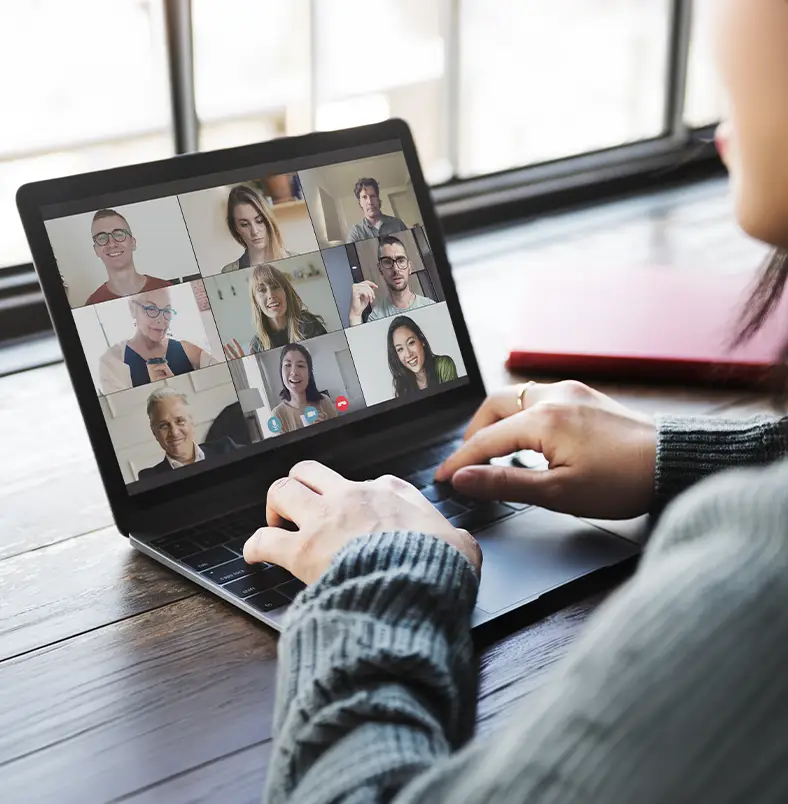 TraumaSolutions Person using a laptop to participate in a video conference with nine people, all visible in individual windows on the screen, discussing deep processing techniques for trauma and exploring Brainspotting in a collaborative session.